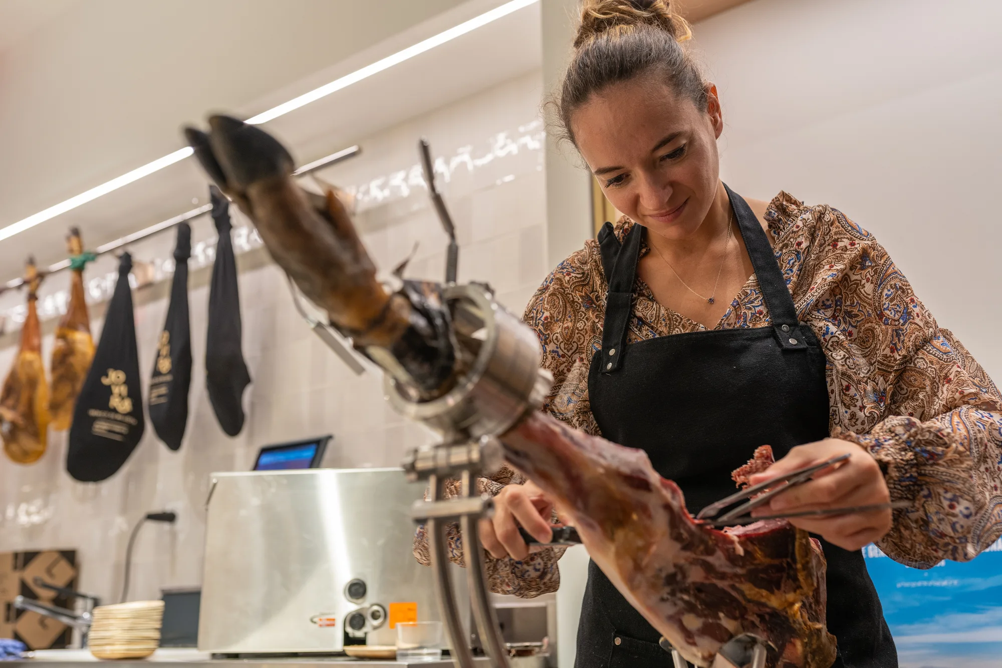Ein Jamón Ibérico wird an der Theke des LA DULA Ladens aufgeschnitten