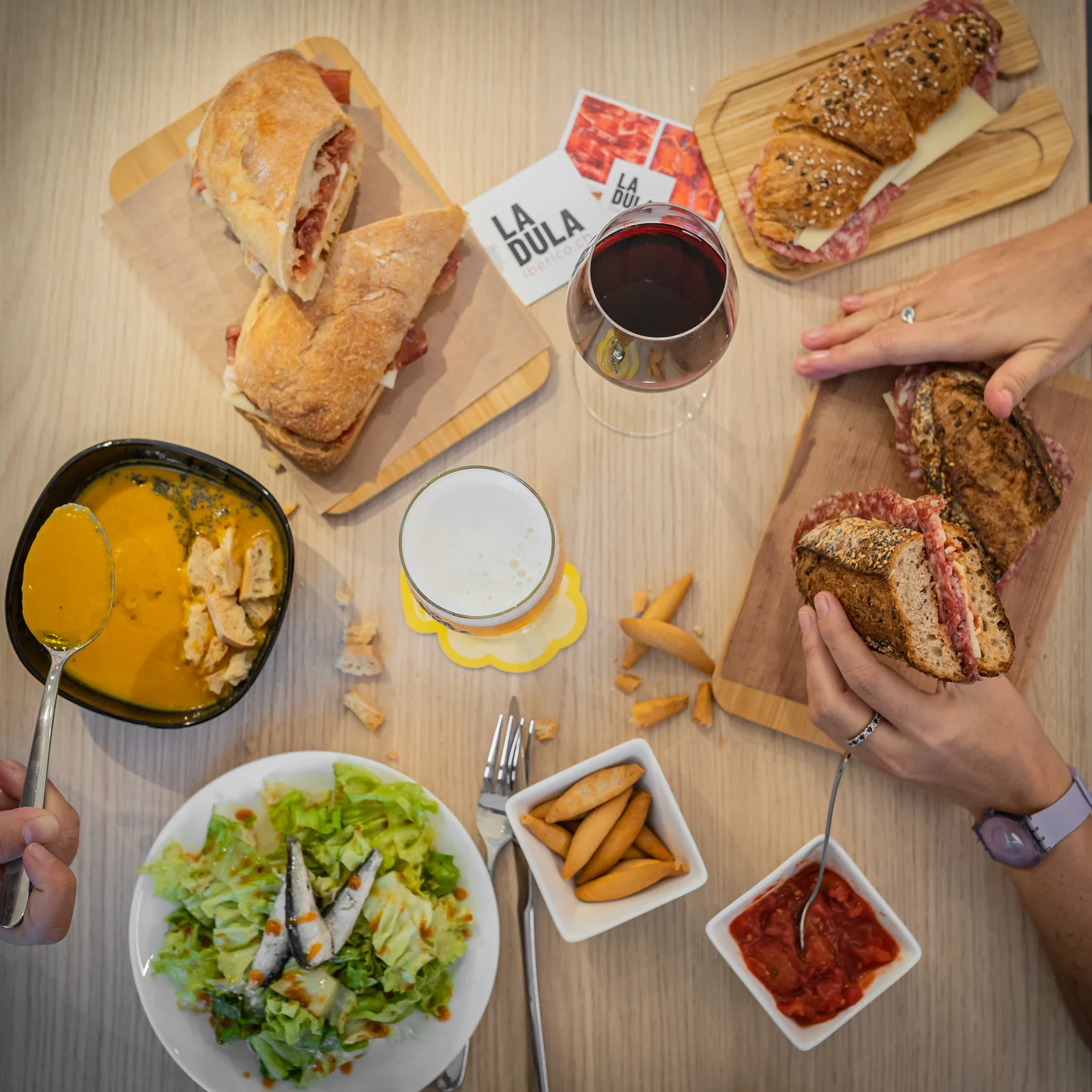 Lunch table at LA DULA: gazpacho, bocadillos, salad and a beer, seen from above